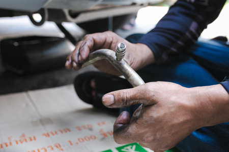 Auto mechanic repairing a car at service station, closeup of handsの写真素材