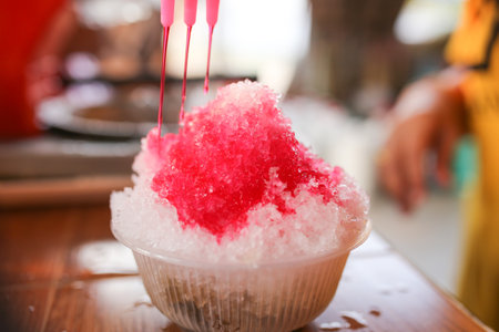 Ice cream in a bowl on a wooden table with blurred background.の写真素材