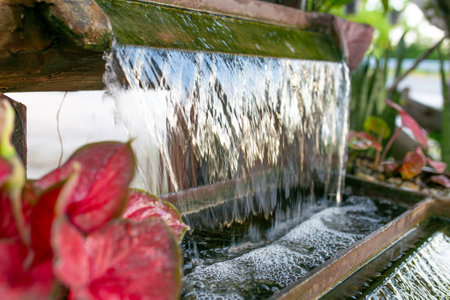Water flowing from a fountain in the garden, closeup of photoの写真素材