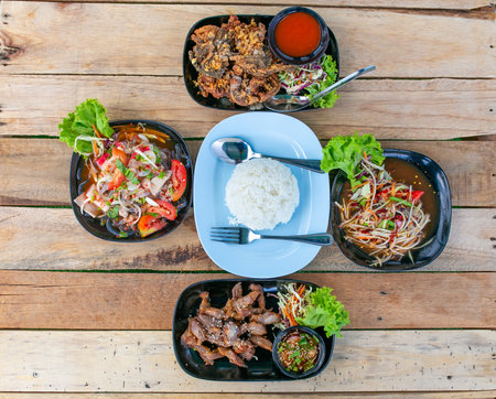 Top view of thai food in black plate on wooden table.の写真素材