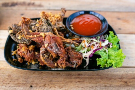 Fried chicken with sweet and sour sauce on wooden background, Thailand.の写真素材