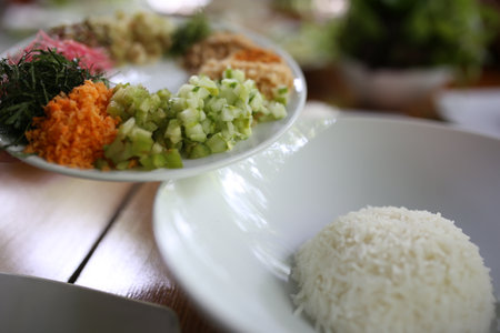 Cucumber and carrot salad with rice in white plate on tableの写真素材