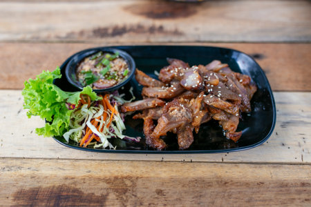Korean style grilled pork with spicy sauce and vegetable on wooden backgroundの写真素材