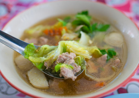 Thai style noodle soup with pork and vegetable in white bowlの写真素材