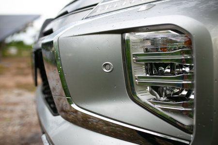 Closeup of the headlight of a modern car in the countrysideの写真素材