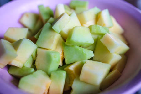 Slices of sweet green cantaloupe in a bowl, close-up.の写真素材