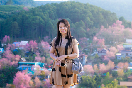 Beautiful asian woman standing on the top of mountain and looking at cameraの写真素材