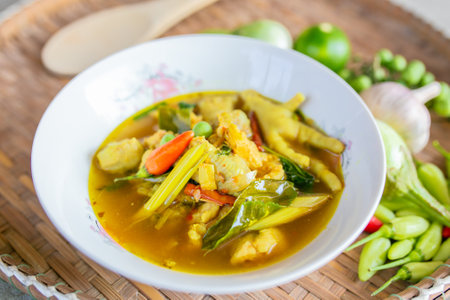Thai green curry with chciken and vegetables in white bowl on wooden tableの写真素材