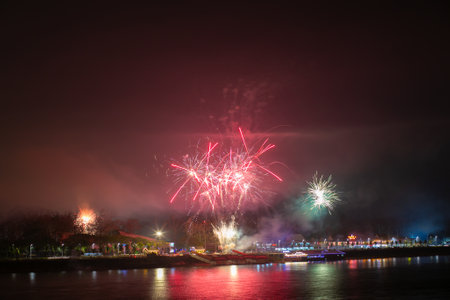 Colorful fireworks of various colors over the river in the night.の写真素材