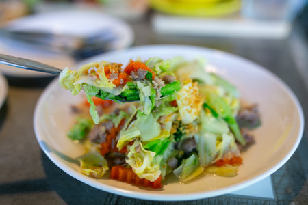Stir-fried Chinese cabbage with pork and vegetable on white plateの写真素材