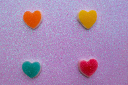 Colorful jelly candies in heart shape on pink background. Top view.の写真素材