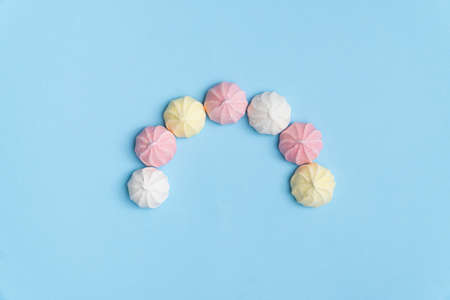 Sweet meringue cookies arranged in semi-circle. Pastel colors. Minimal concept flat lay.の写真素材