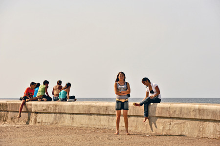 HAVANA, CUBA, MAY 9, 2009  People sitting on a railing in Malecon beach boulevard in Havana, Cuba, on May 9th, 2009 のeditorial素材