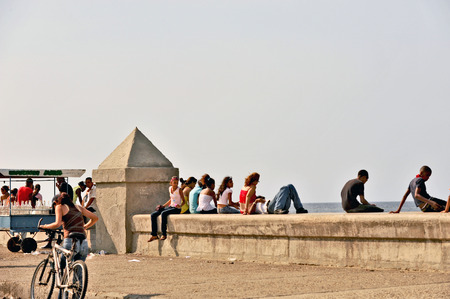 HAVANA, CUBA, MAY 9, 2009  People sitting on a railing in Malecon beach boulevard in Havana, Cuba, on May 9th, 2009 のeditorial素材