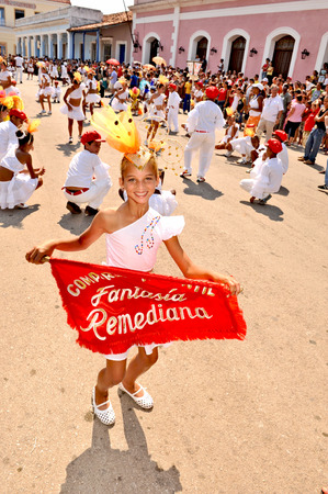 REMEIDOS, CUBA, MAY 7, 2009  A young girl dancing on the street and waving a red flag during a town festival, in Remeidos, Cuba, on May 7th, 2009 のeditorial素材
