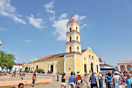 REMEIDOS, CUBA, MAY 7, 2009  People hanging out in the daytime in the town centre in Remeidos, Cuba, on May 7th, 2009  A yellow building with a tower in the background のeditorial素材