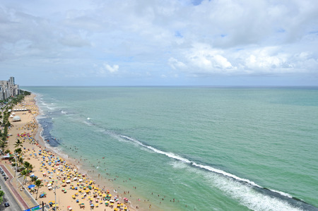 Recife, Pernambuco, Brazil, 2009  A view to the city beach with lots of Brazilian people sunbathing and swimming, and umbrellas, a view from the top of a skyscraper の写真素材