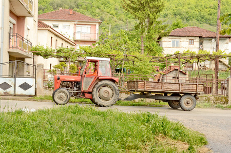 OHRID, MACEDONIA, MAY 17, 2011  A tractor with a trailer driving on an asphalt road in the countryside of Ohrid, Macedonia, on May 17th, 2011 のeditorial素材