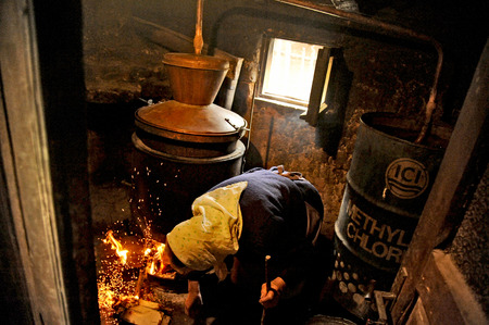 OHRID, MACEDONIA, MAY 17, 2011  And old Macedonian lady making home made alcohol in the countryside of Ohrid, Macedonia, on May 17th, 2011 のeditorial素材