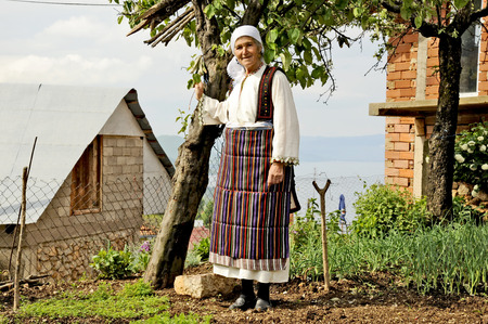 OHRID, MACEDONIA, MAY 17, 2011  An old Macedonian lady posing in a national suit with a butchers knife in her hand, in the countryside of Ohrid, Macedonia, on May 17th, 2011のeditorial素材