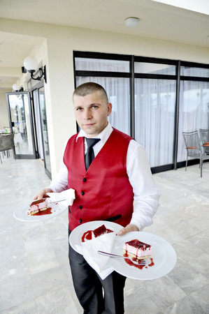OHRID, MACEDONIA, MAY 20, 2011  A young male waiter serving a plate of anti-pasta, in Ohrid, Macedonia, on May 20, 2011 のeditorial素材