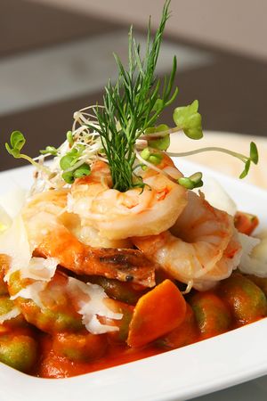 four shrimps with caper and artichoke on the tableの写真素材