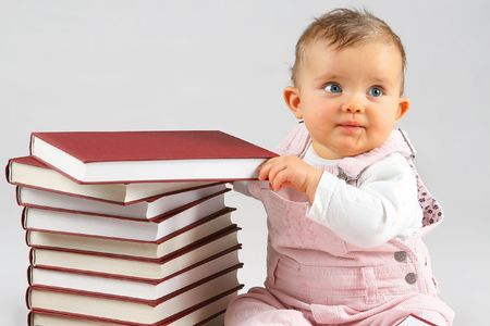 small baby girl and many red books with red coverの写真素材