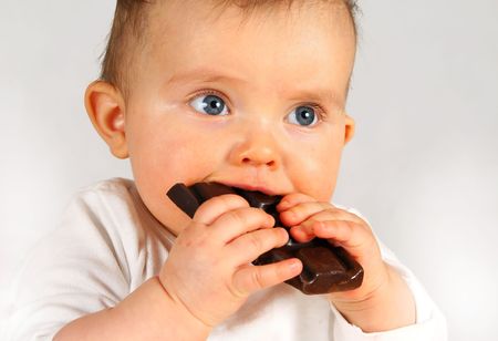 small baby girl holding big chocolate in handsの写真素材