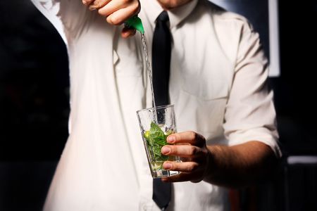 barman making drink with mint and iceの写真素材