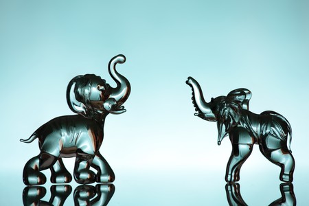 Two glass elephant figurines over blue backgroundの写真素材