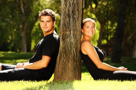 Young cute couple resting in the park and smilingの写真素材