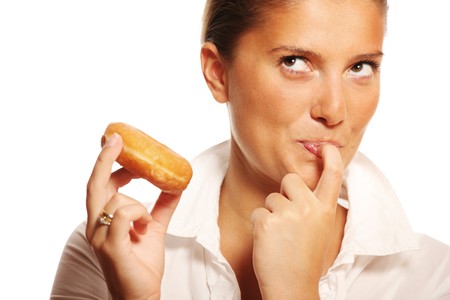 A picture of a young wife trying to resist the temptation of eating a donutの写真素材
