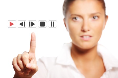 A picture of a young pretty businesswoman touching the button over white backgroundの写真素材