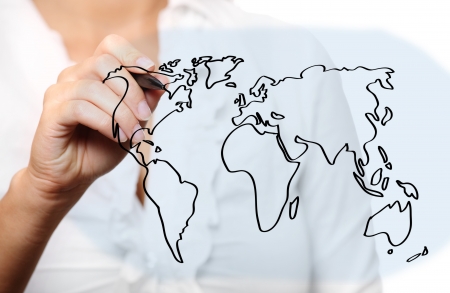 A picture of a young woman drawing a world map over white backgroundの写真素材