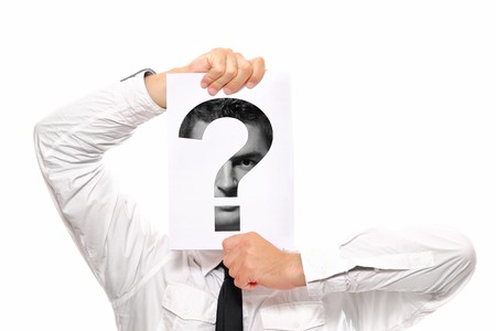 Businessman holding a piece of paper over his face with a question mark on it