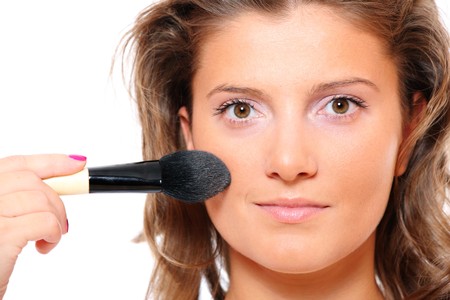 A close-up of a pretty young woman putting on natural makeupの写真素材