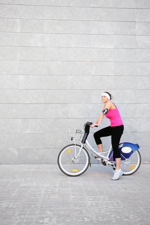A picture of a young girl on a bike over grey urban backgroundの写真素材