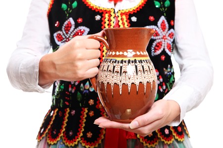 A close-up of a jug over traditional Polish outfitの写真素材