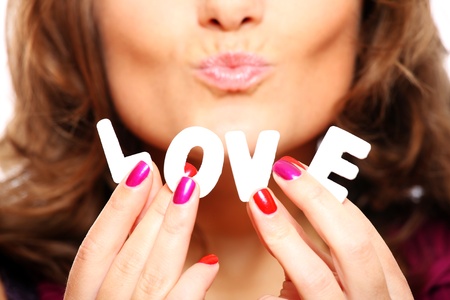 A close up of love inscription over a beautiful girl sending a kissの写真素材