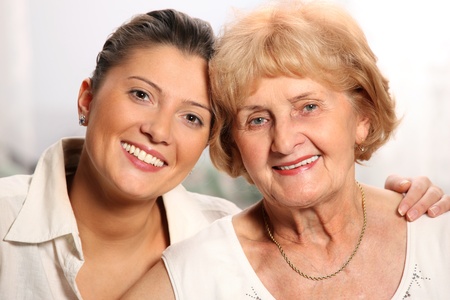 A beautiful portrait of grandma and grandaughter smiling over white backgroundの写真素材