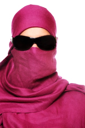 A portrait of an arabic woman face hidden behind a purple scarfの写真素材