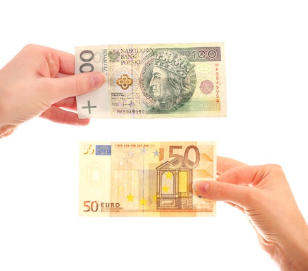 A picture of hands holding Polish hundred-zloty note and fifty-euro note over white backgroundの写真素材