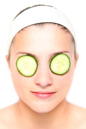 A picture of a young relaxed woman with her eyes covered with cucumber slicesの写真素材