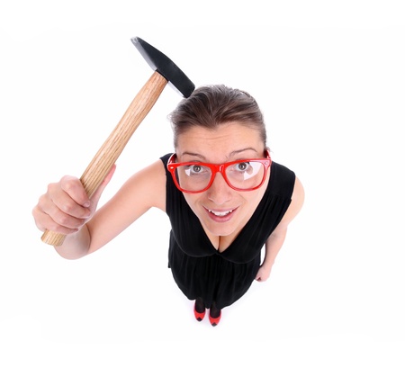 A funny portrait of a young frustrated woman with a hammer over white backgroundの写真素材