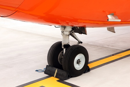A picture of an orange undercarriage of a business jet standing on the apron の写真素材