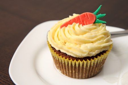 A picture of a carrot cupcake served on a white plateの写真素材