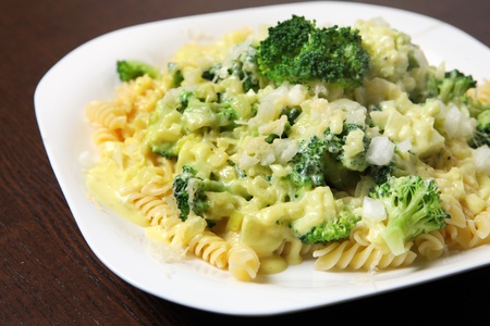 A picture of fresh pasta with broccoli and beschamel sauce served on a white plateの写真素材