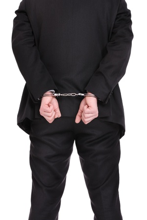 A picture of a businessman in handcuffs standing over white backgroundの写真素材