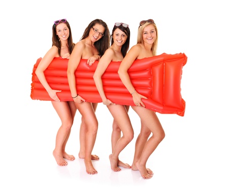 Picture of four happy women covering their body with a red mattress over white backgroundの写真素材