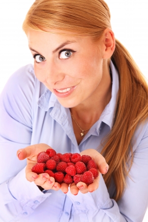 A portrait of a pretty woman with a handful of raspberries over white backgroundの写真素材